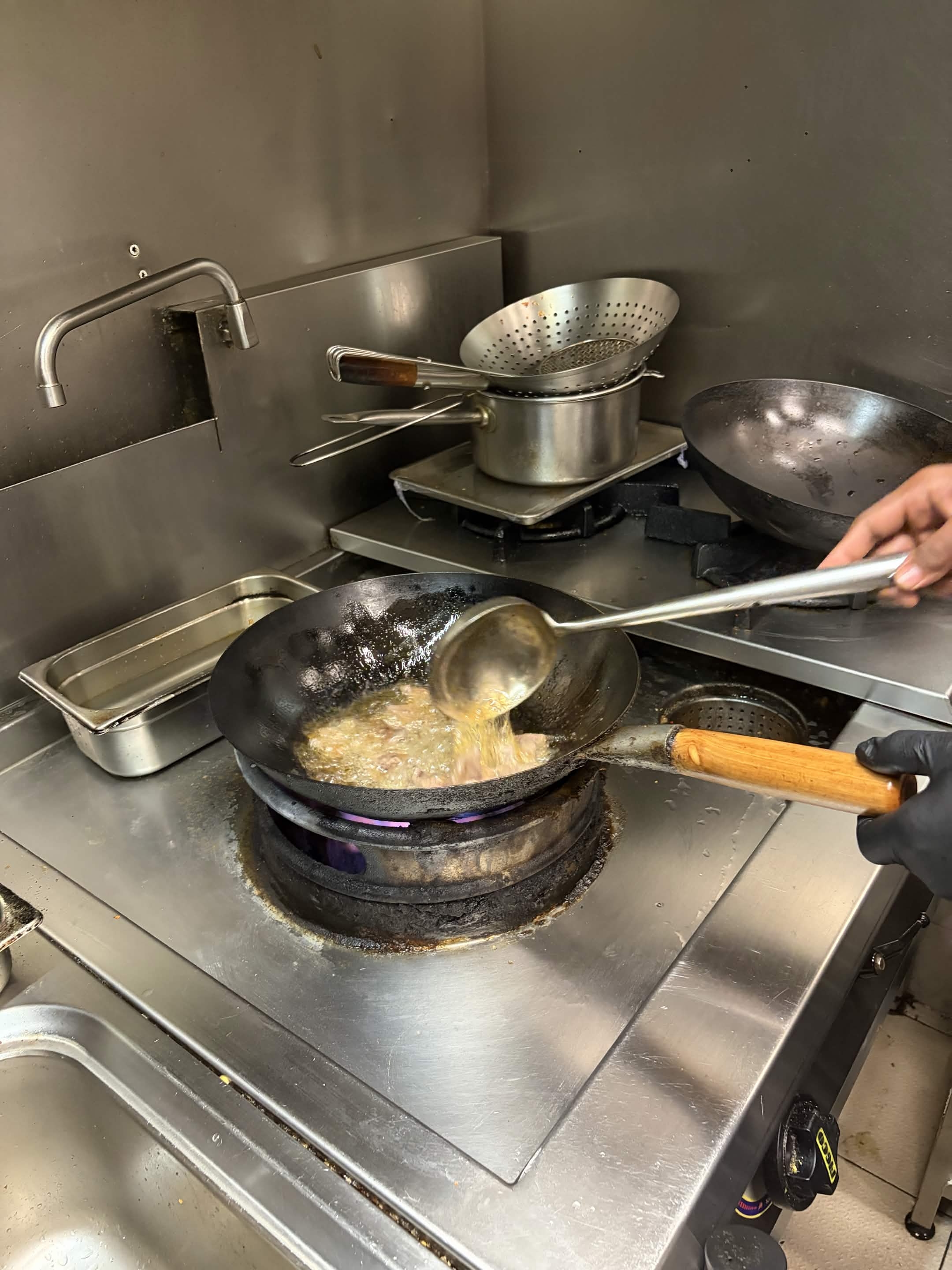 Les nouilles fraîches sont versées dans le wok bouillant