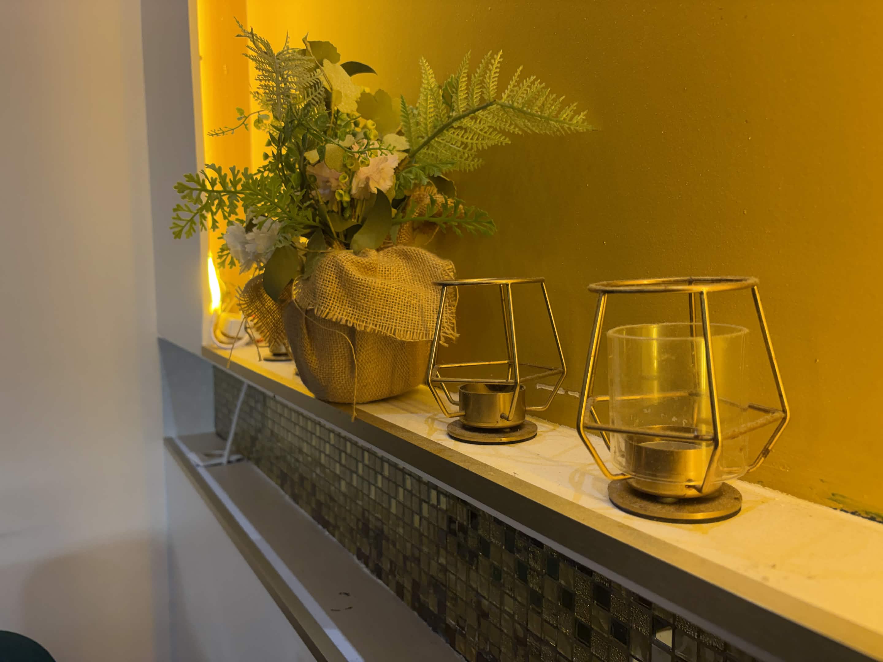 Lanternes dorées et végétation sur fond ocre, détail de la décoration